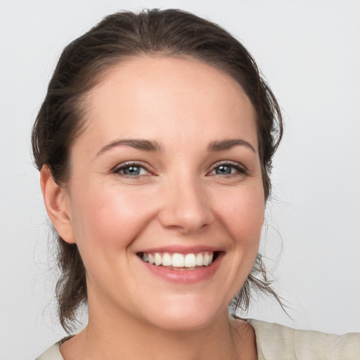 Joyful white young-adult female with medium  brown hair and grey eyes