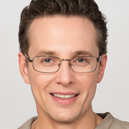 Joyful white adult male with short  brown hair and grey eyes