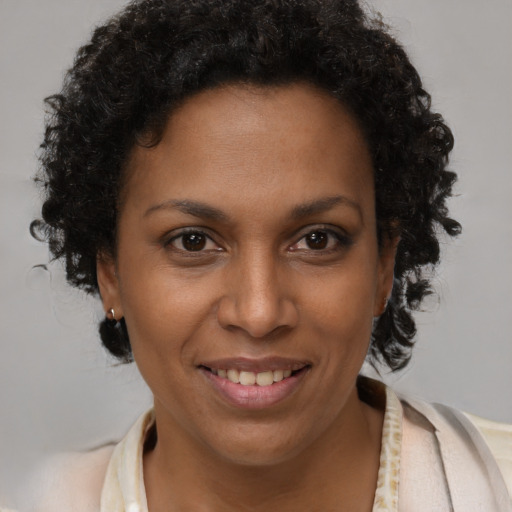 Joyful black adult female with short  brown hair and brown eyes