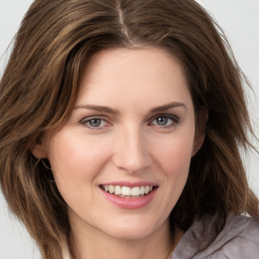 Joyful white young-adult female with long  brown hair and grey eyes