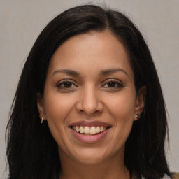 Joyful latino young-adult female with long  brown hair and brown eyes