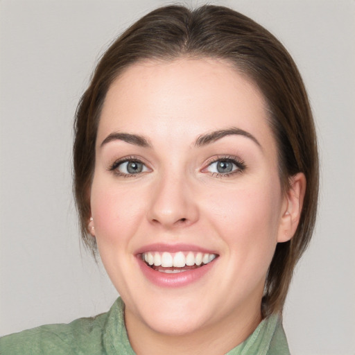 Joyful white young-adult female with medium  brown hair and green eyes