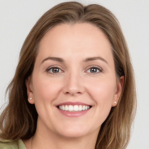 Joyful white young-adult female with long  brown hair and grey eyes