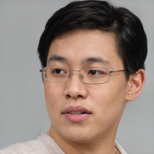 Joyful asian young-adult male with short  brown hair and brown eyes