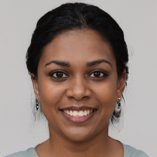 Joyful black young-adult female with medium  black hair and brown eyes