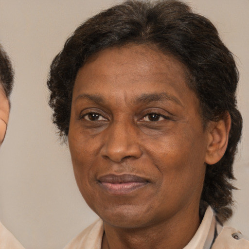 Joyful black adult female with medium  brown hair and brown eyes