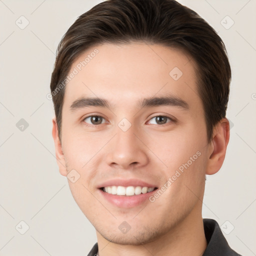 Joyful white young-adult male with short  brown hair and brown eyes