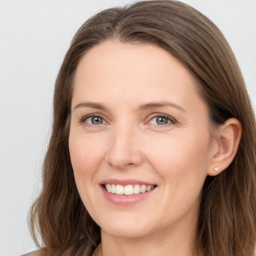 Joyful white young-adult female with long  brown hair and grey eyes