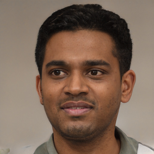 Joyful black young-adult male with short  black hair and brown eyes