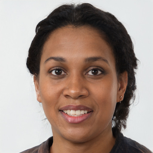 Joyful black young-adult female with long  brown hair and brown eyes