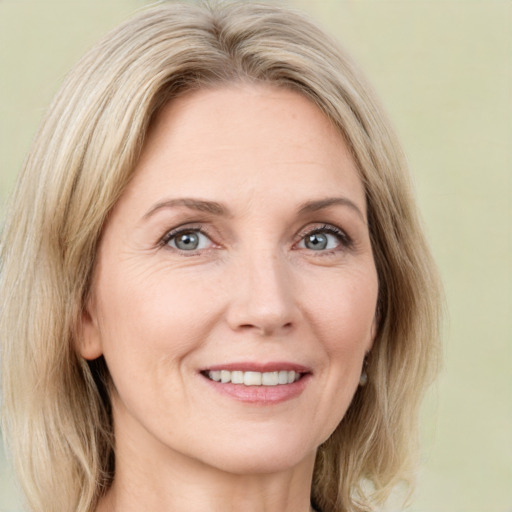 Joyful white adult female with medium  brown hair and green eyes