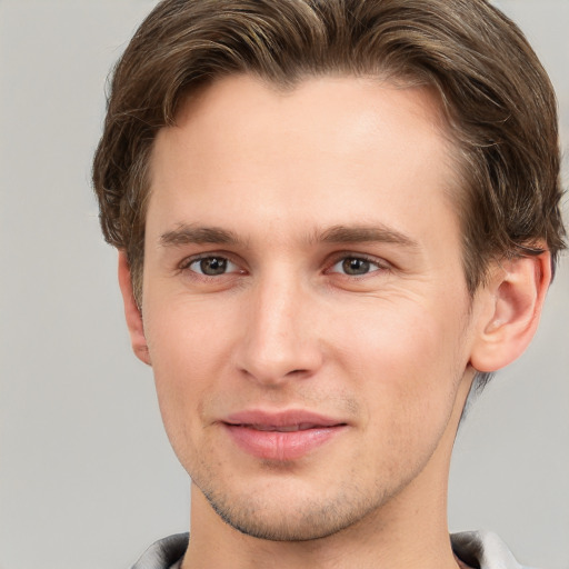 Joyful white young-adult male with short  brown hair and grey eyes