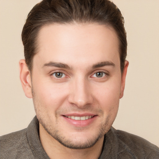 Joyful white young-adult male with short  brown hair and grey eyes