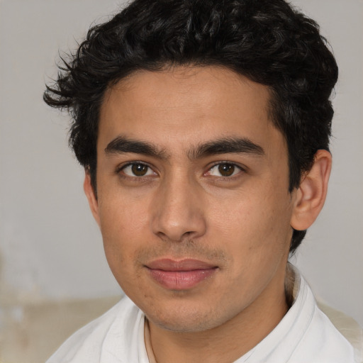 Joyful latino young-adult male with short  brown hair and brown eyes