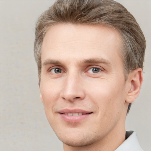 Joyful white young-adult male with short  brown hair and grey eyes