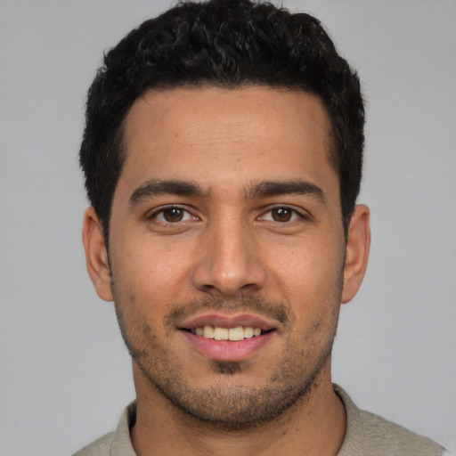 Joyful white young-adult male with short  black hair and brown eyes