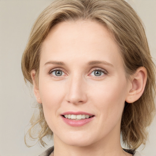 Joyful white young-adult female with medium  brown hair and blue eyes