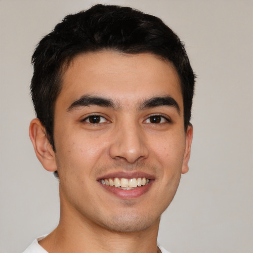 Joyful latino young-adult male with short  brown hair and brown eyes