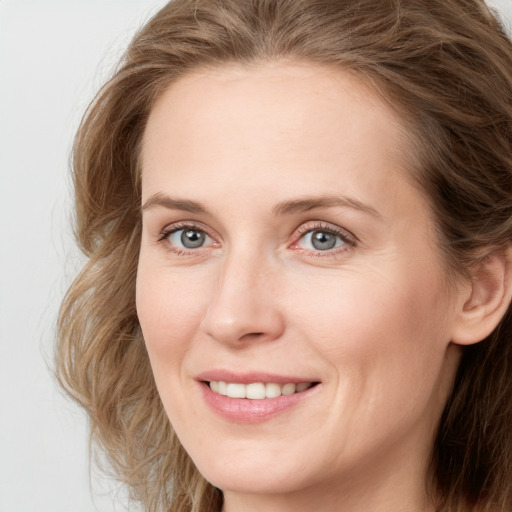 Joyful white young-adult female with long  brown hair and blue eyes