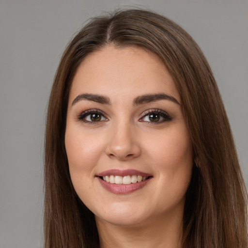 Joyful white young-adult female with long  brown hair and brown eyes