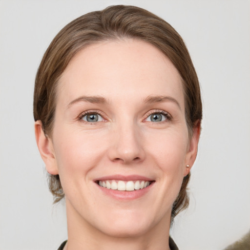 Joyful white young-adult female with medium  brown hair and grey eyes