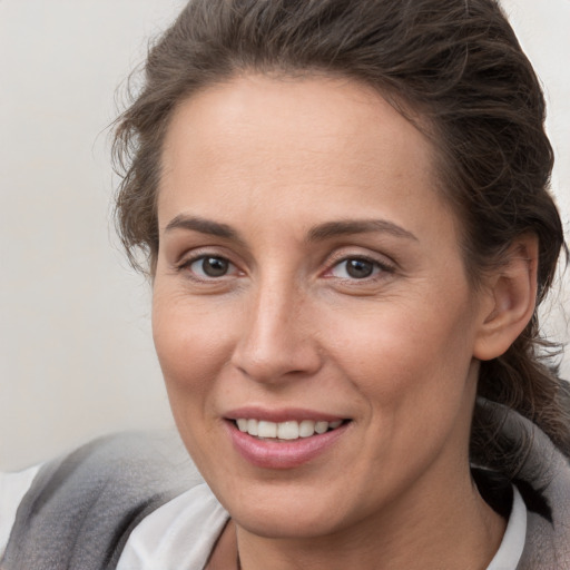 Joyful white adult female with medium  brown hair and brown eyes