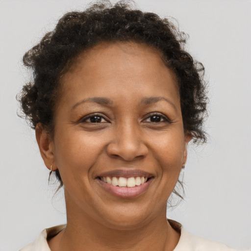 Joyful black adult female with short  brown hair and brown eyes