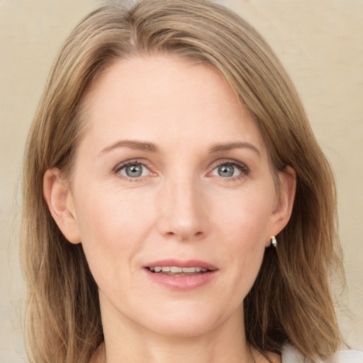 Joyful white adult female with medium  brown hair and green eyes