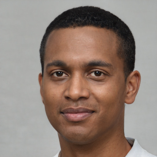 Joyful black young-adult male with short  black hair and brown eyes