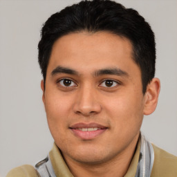 Joyful latino young-adult male with short  brown hair and brown eyes