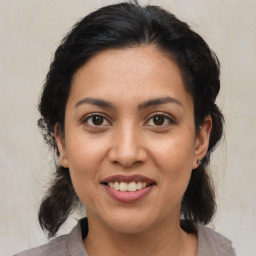 Joyful latino young-adult female with medium  brown hair and brown eyes