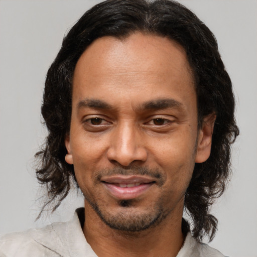 Joyful latino adult male with medium  brown hair and brown eyes