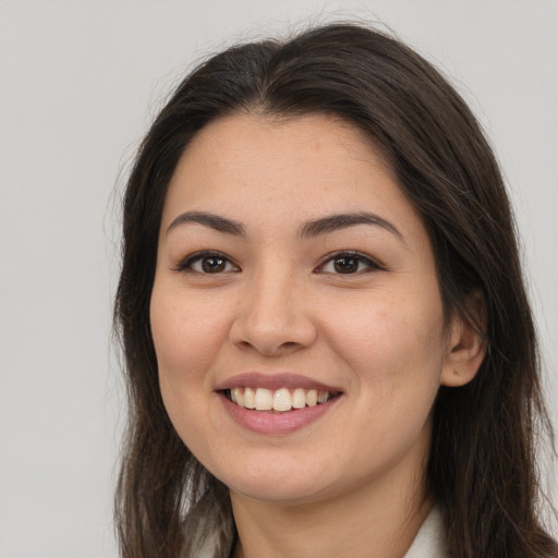 Joyful latino young-adult female with long  brown hair and brown eyes