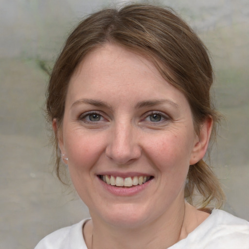 Joyful white young-adult female with medium  brown hair and blue eyes