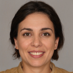 Joyful white adult female with medium  brown hair and brown eyes