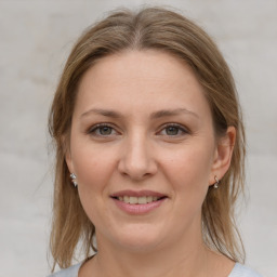 Joyful white young-adult female with medium  brown hair and grey eyes