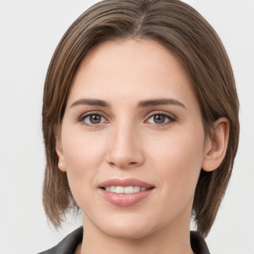 Joyful white young-adult female with medium  brown hair and grey eyes