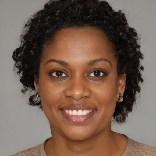 Joyful black young-adult female with medium  brown hair and brown eyes