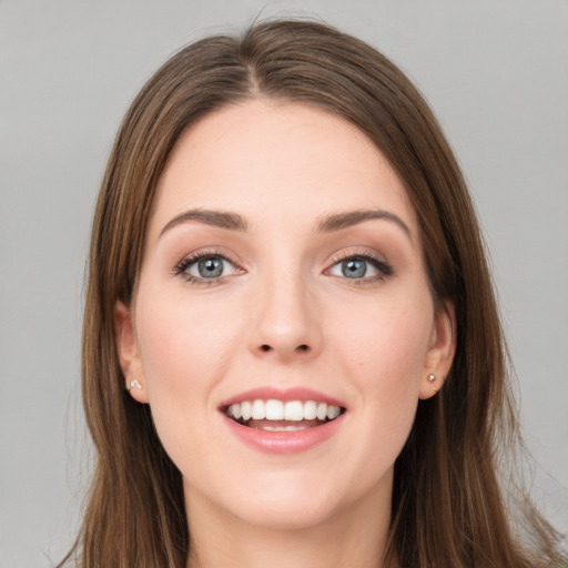 Joyful white young-adult female with long  brown hair and blue eyes