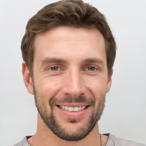 Joyful white young-adult male with short  brown hair and grey eyes