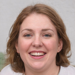 Joyful white adult female with medium  brown hair and blue eyes