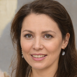 Joyful white adult female with long  brown hair and grey eyes