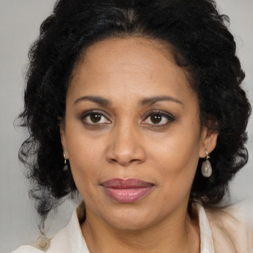 Joyful latino adult female with medium  brown hair and brown eyes