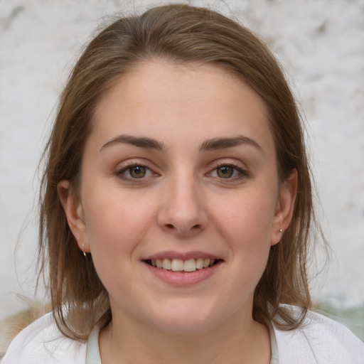 Joyful white young-adult female with medium  brown hair and grey eyes