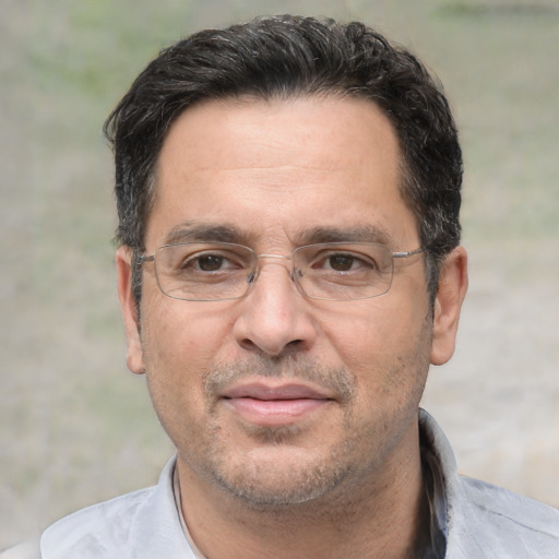 Joyful white adult male with short  black hair and brown eyes