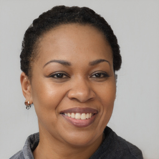 Joyful black adult female with short  brown hair and brown eyes