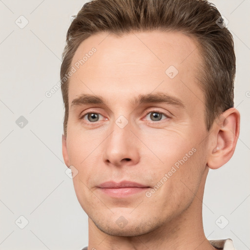 Joyful white young-adult male with short  brown hair and grey eyes