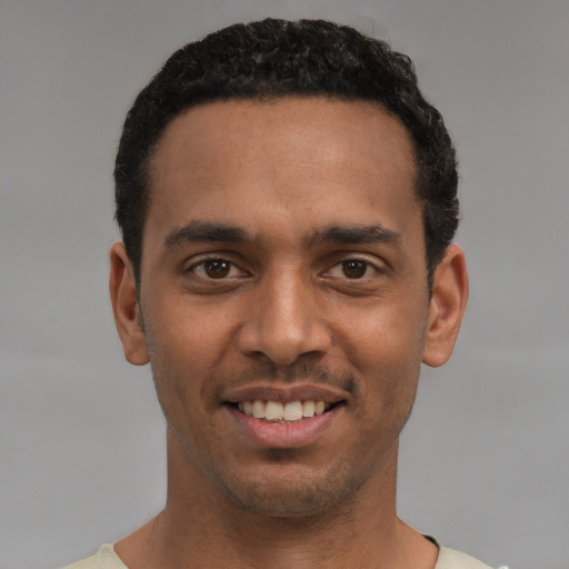 Joyful black young-adult male with short  black hair and brown eyes
