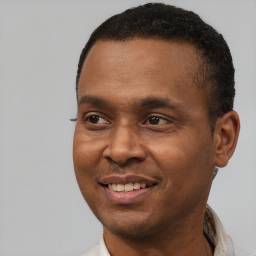 Joyful black young-adult male with short  brown hair and brown eyes