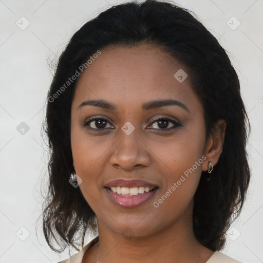 Joyful black young-adult female with long  black hair and brown eyes